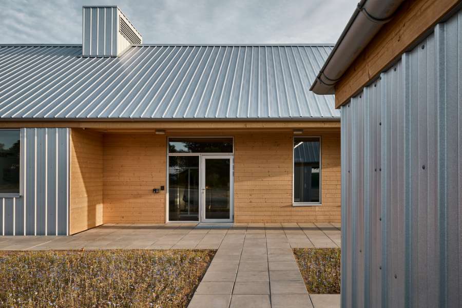 The rib sheets of Jordbærmarken create a rural atmosphere and inspire children to play outdoors, Børnehuset Jordbærmarken, Rodskovvej 59, 8543 Hornslet